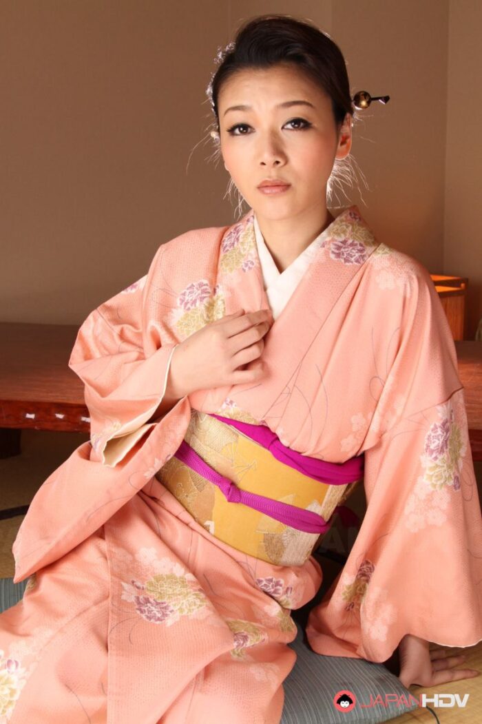 Minako Uchida reveals hot boobies and shaved pussy under pink kimono.